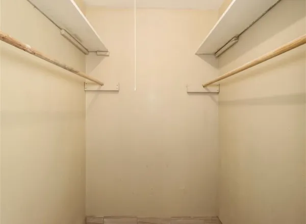 a view of a hallway with wooden floor and a bathroom