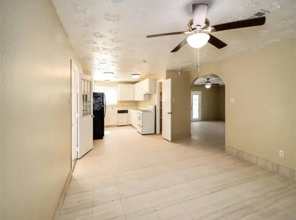 a view of a kitchen with a refrigerator and a ceiling fan