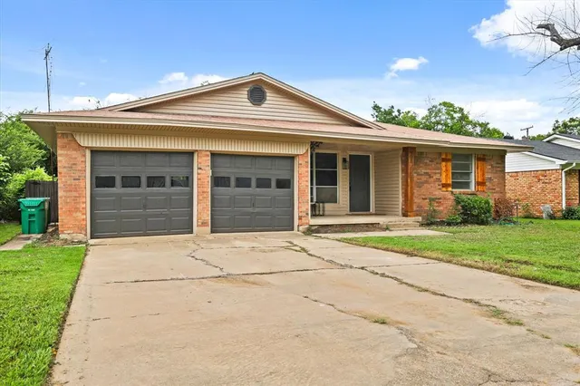 a front view of a house with a garden and yard