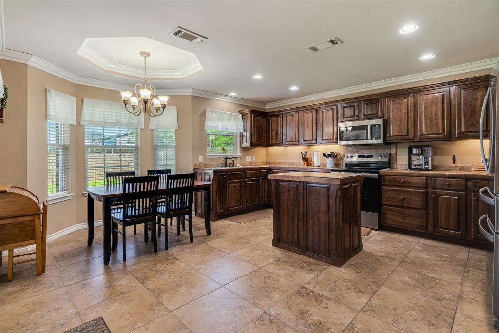 1810 Meadowview Drive Reno, TX 75462 - Photo 3 of 17 a kitchen with stainless steel appliances granite countertop wooden cabinets a sink a stove a dining table and chairs