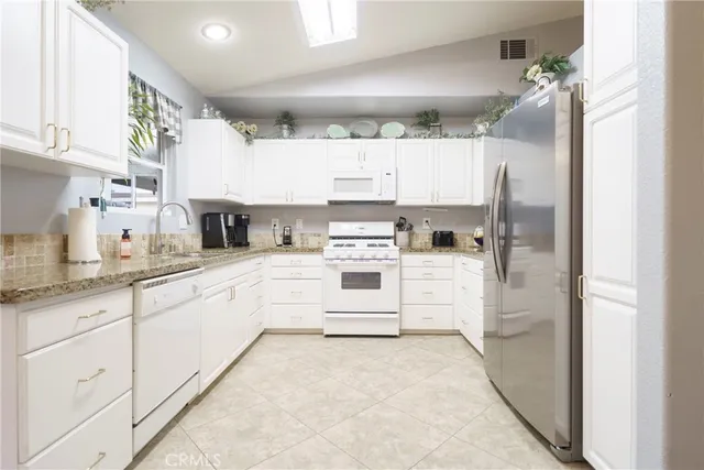 a kitchen with white cabinets and white appliances
