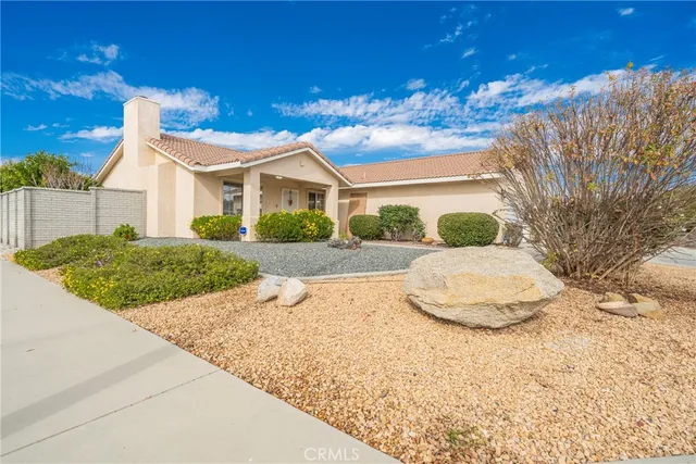 a view of a white house next to a yard with road