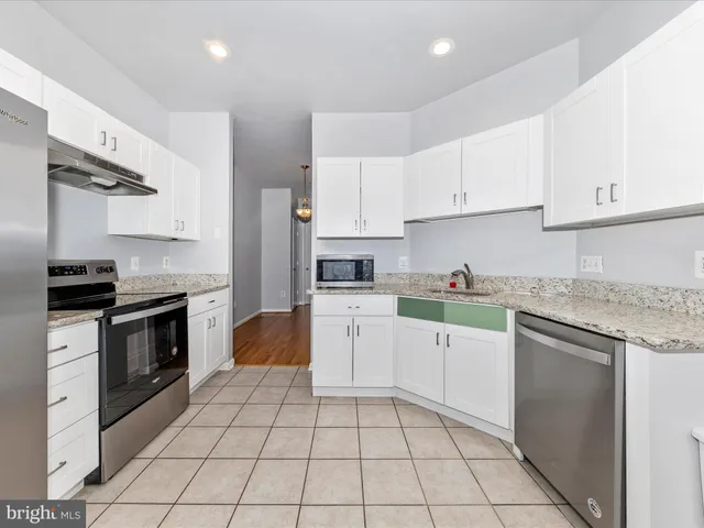 a kitchen with granite countertop a stove top oven sink and cabinets