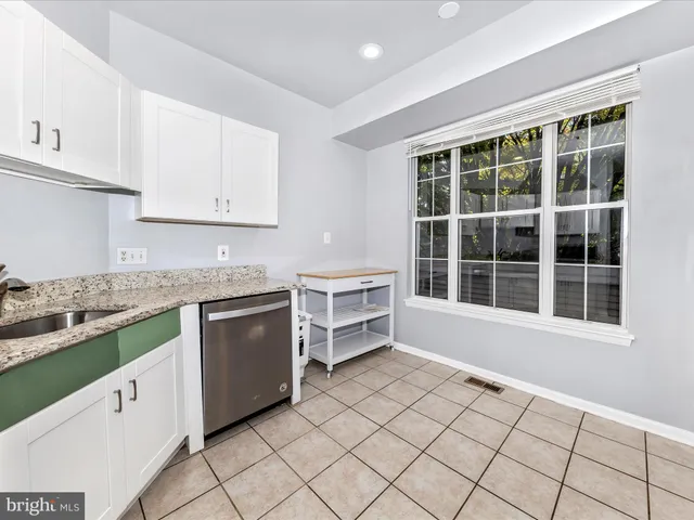 a kitchen with a stove sink and cabinets
