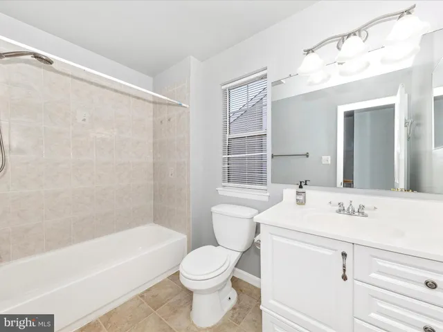 a bathroom with a sink a toilet a vanity and bathtub