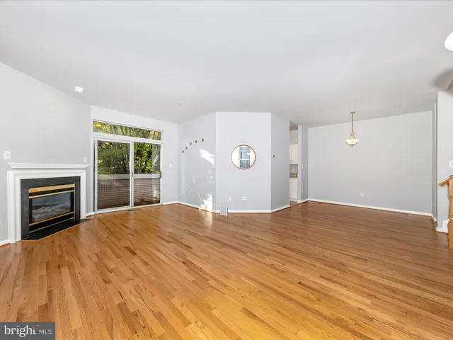 a view of empty room with wooden floor and fireplace