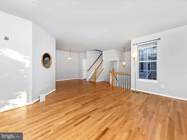 a view of an empty room with wooden floor