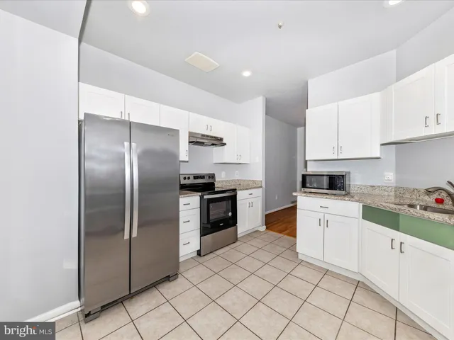 a kitchen with cabinets and stainless steel appliances