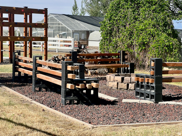 812 East Bates Cyn Road Tooele, UT 84074 - Photo 94 of 144 Outdoor gathering space featuring a stone-lined fire pit, surrounded by wood and concrete block benches