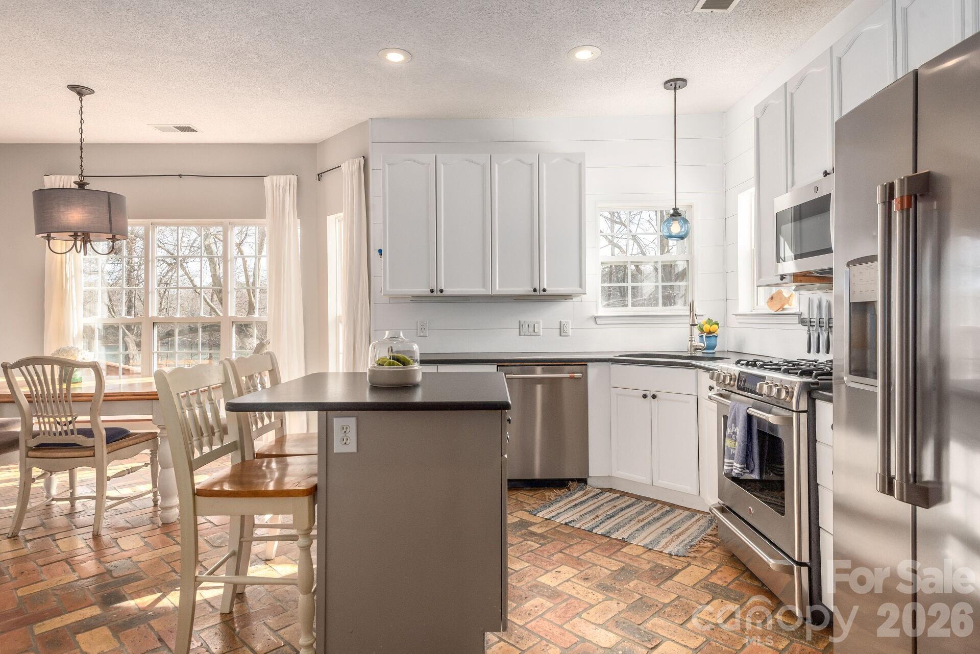 156 Lighthouse Road Mount Holly, NC 28120 - Photo 7 of 39 a kitchen with stainless steel appliances granite countertop a stove top oven a sink refrigerator and cabinets