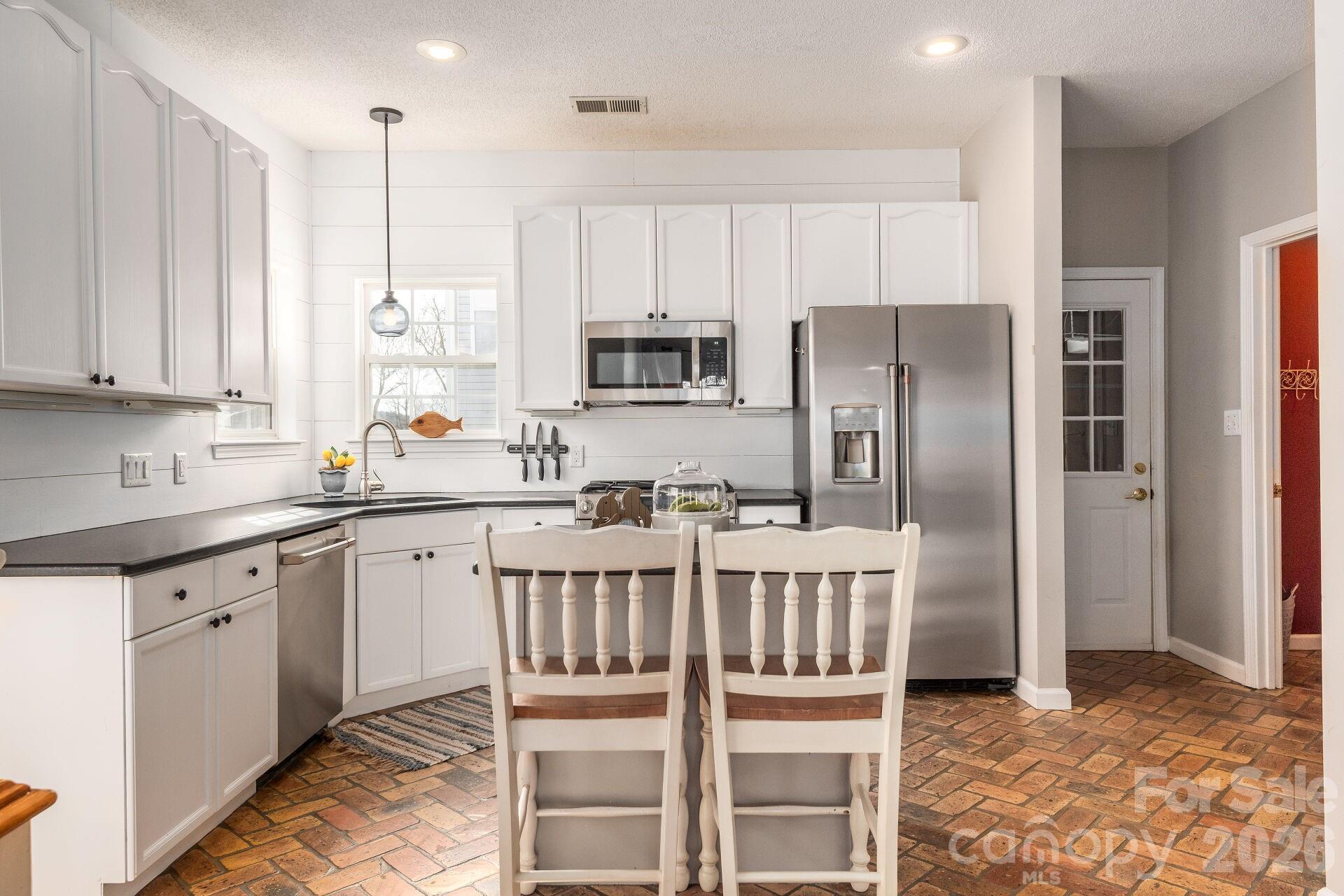 156 Lighthouse Road Mount Holly, NC 28120 - Photo 9 of 39 a kitchen with stainless steel appliances granite countertop a refrigerator a stove a sink and white cabinets