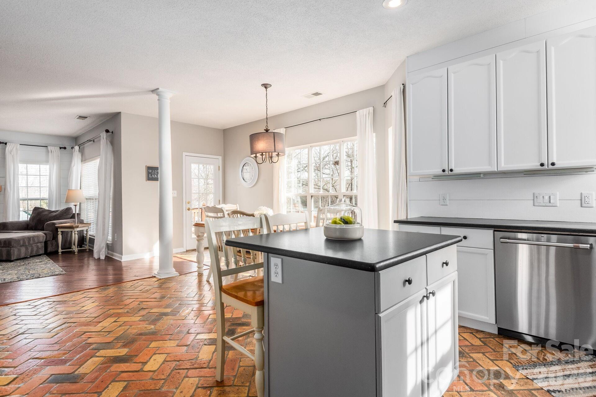 156 Lighthouse Road Mount Holly, NC 28120 - Photo 10 of 39 a kitchen with stainless steel appliances granite countertop a stove a sink a dining table and chairs with wooden floor