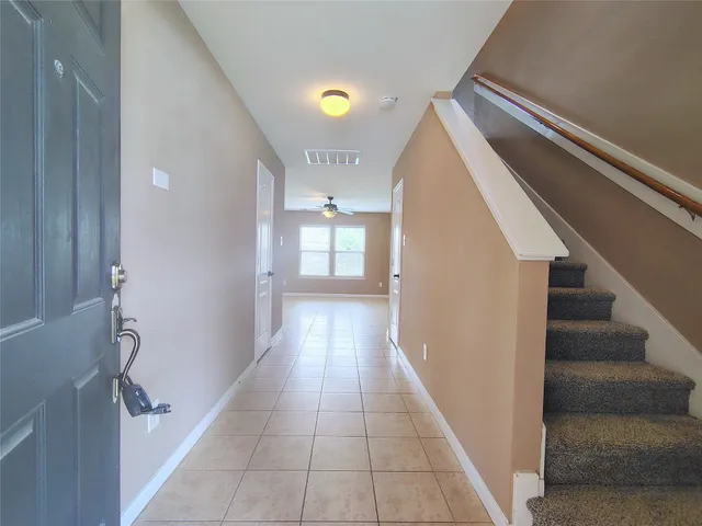 a view of a hallway with wooden floor and staircase