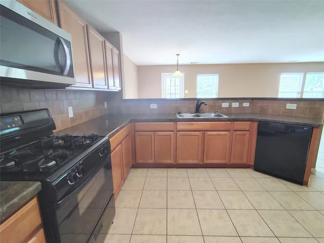 a kitchen with stainless steel appliances a sink a stove top oven and cabinets