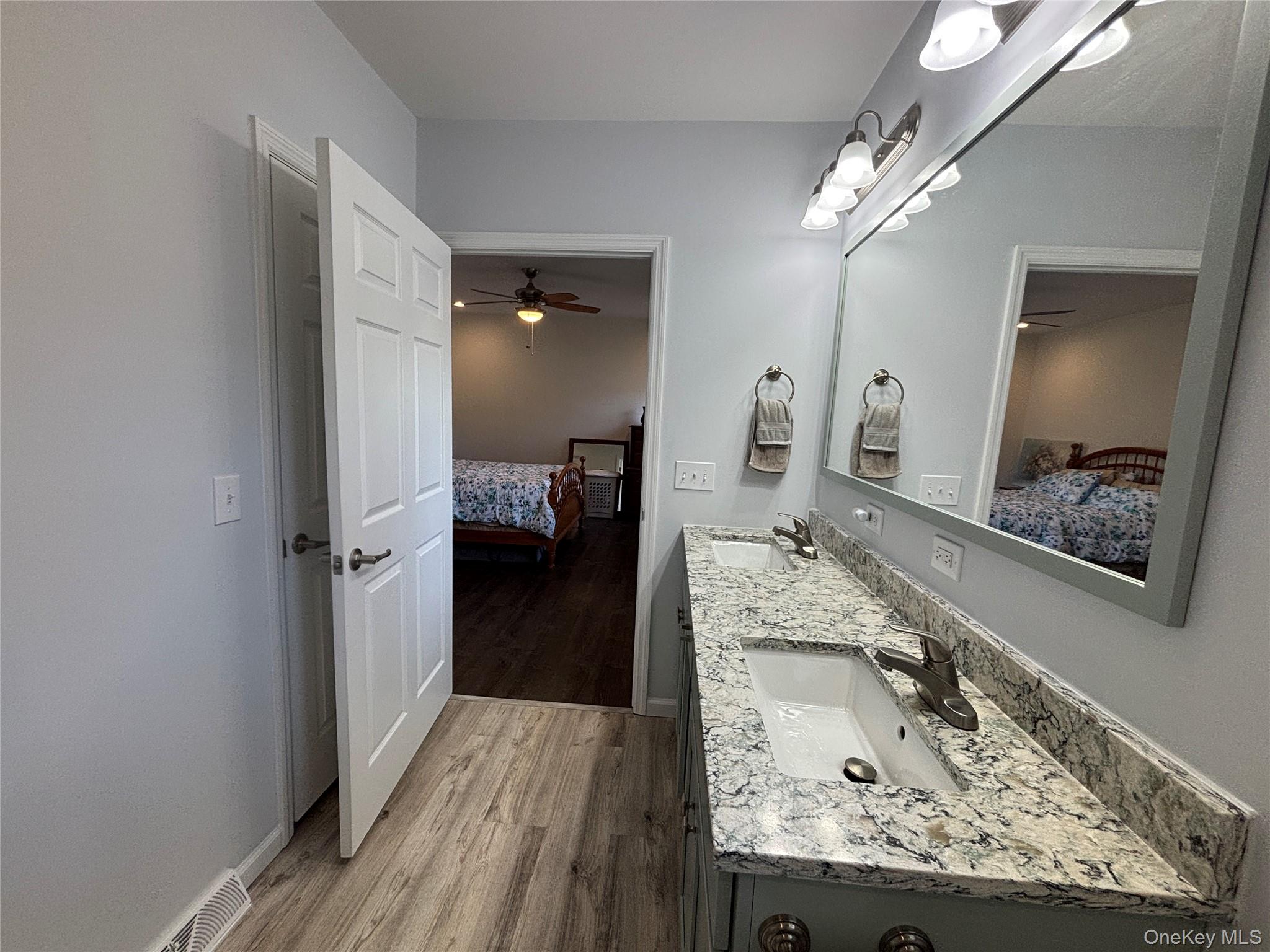 1661 Old Country Road, Unit 563 Riverhead, NY 11901 - Photo 32 of 43 a en suite bathroom with a granite countertop sink and a mirror
