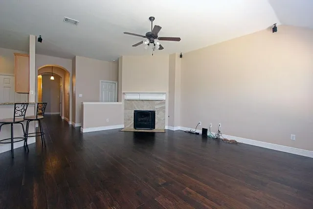 a view of empty room with wooden floor and fireplace