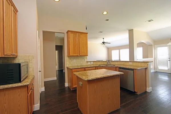 a kitchen with a sink cabinets and wooden floor