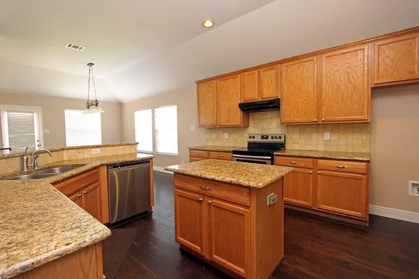 a kitchen with granite countertop kitchen island wooden floors granite counter tops and a window