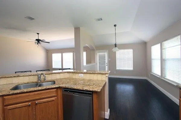 a kitchen with granite countertop kitchen island sink and window