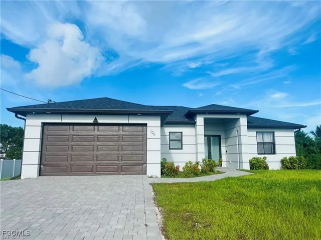 a front view of a house with a yard and garage