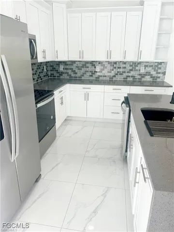 a kitchen with a sink a refrigerator and cabinets