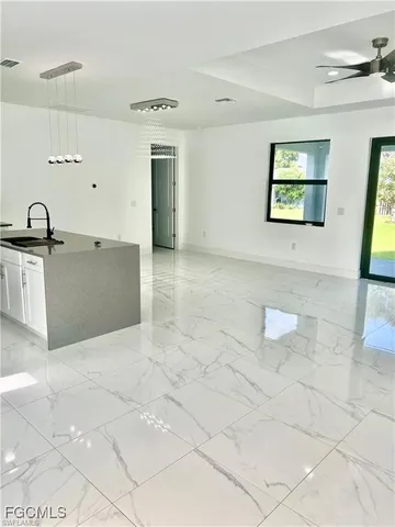 a view of a kitchen with kitchen island a sink granite counter tops and a stove