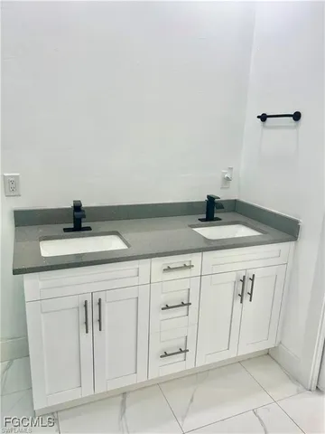 a sink with white cabinets