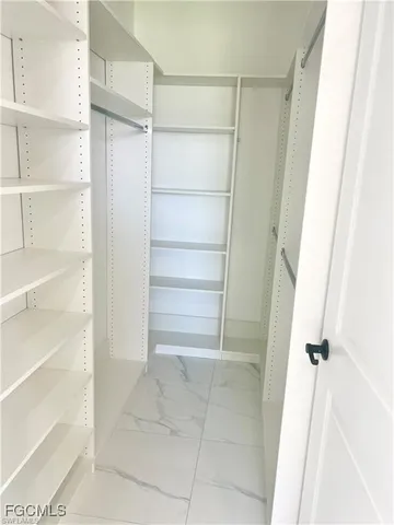 a view of walk in closet with empty racks