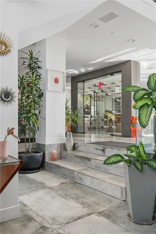 a living room with patio furniture and a potted plant