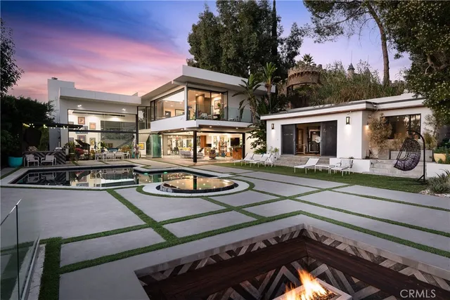 a front view of a house with swimming pool table and chairs