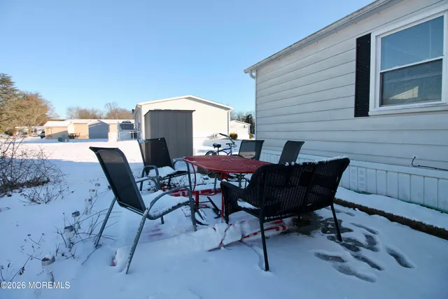 a patio with table and chairs and potted plants