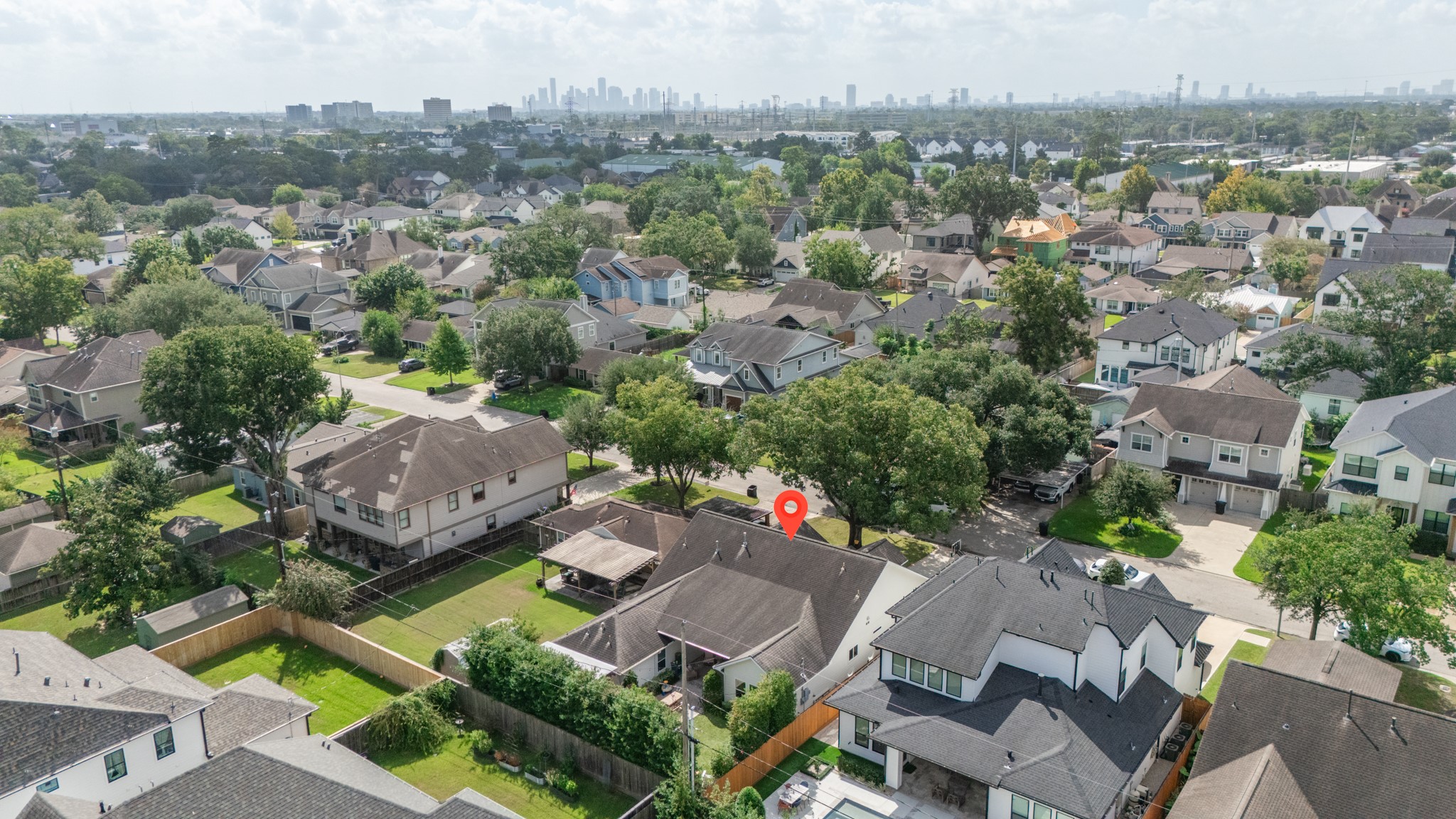 1722 Chippendale Road Houston, TX 77018 - Photo 38 of 41 Charming suburban neighborhood with tree-lined streets and a mix of modern and traditional homes, offering city skyline views in the distance.