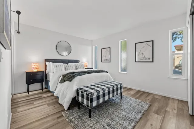 a bedroom with a bed and a potted plant on the dresser