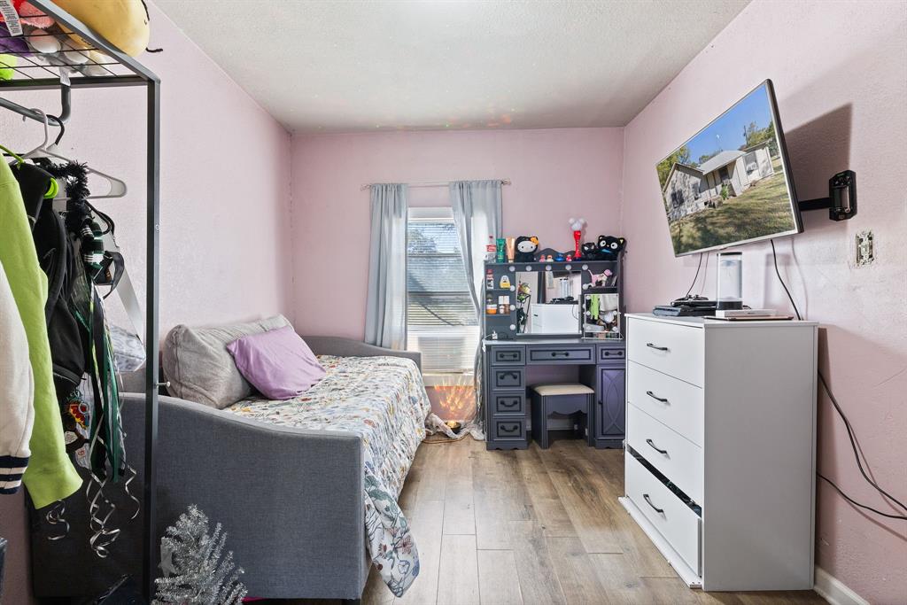 301 South Morrow Street Blue Ridge, TX 75424 - Photo 16 of 30 a living room with furniture a flat screen tv and a floor to ceiling window