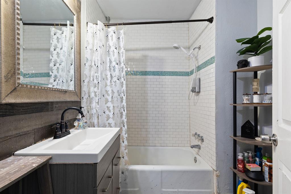 301 South Morrow Street Blue Ridge, TX 75424 - Photo 20 of 30 a bathroom with a sink a mirror and a shower