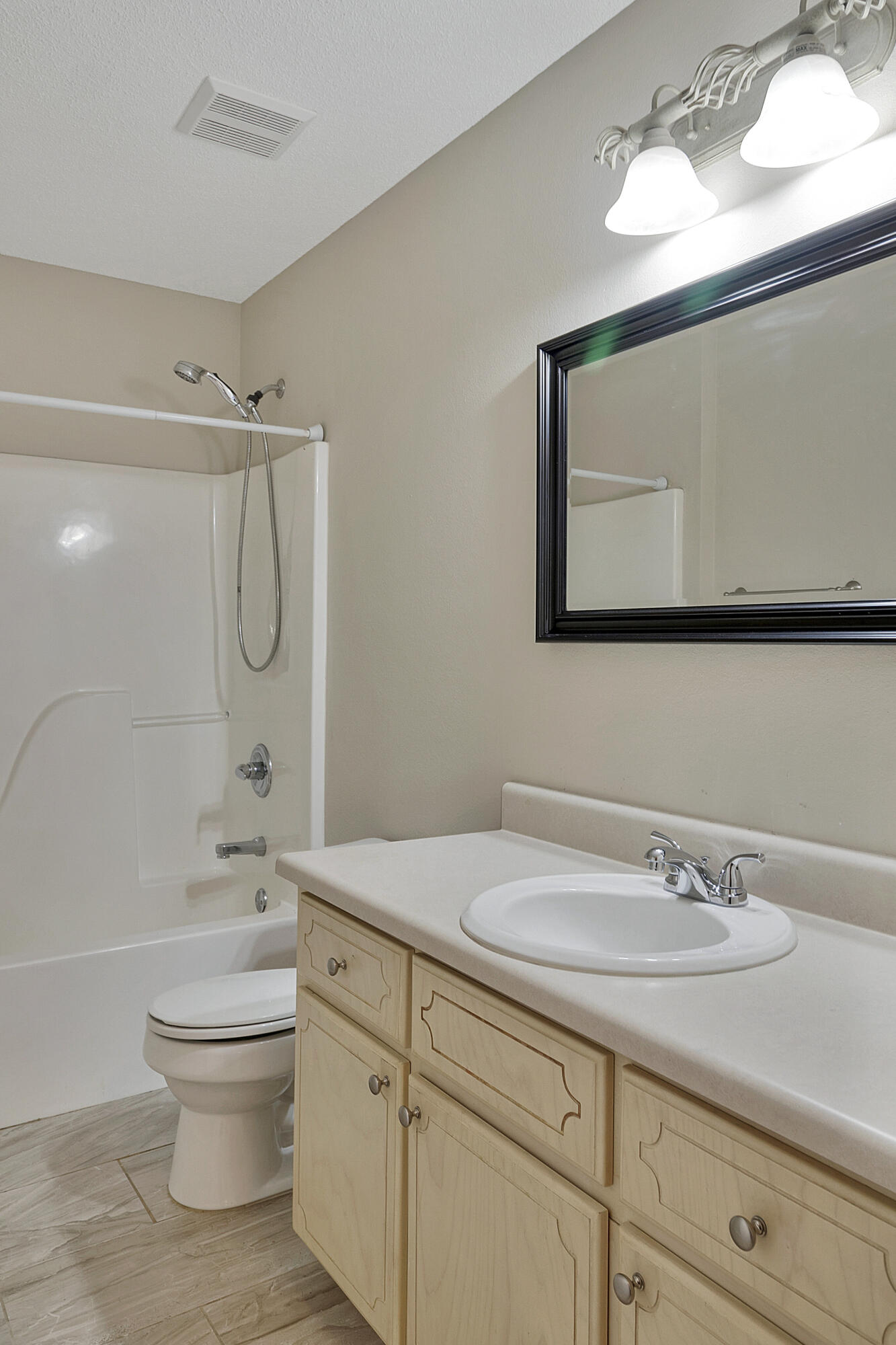 5360 Walker Road Milton, FL 32570 - Photo 12 of 17 a bathroom with a granite countertop toilet a sink and a mirror