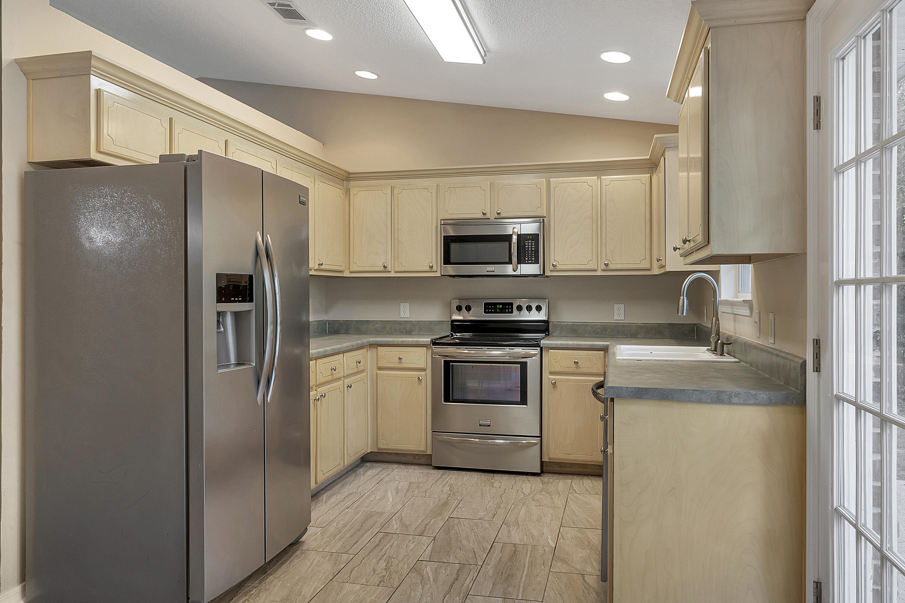 5360 Walker Road Milton, FL 32570 - Photo 6 of 17 a kitchen with stainless steel appliances cabinets a sink and a refrigerator