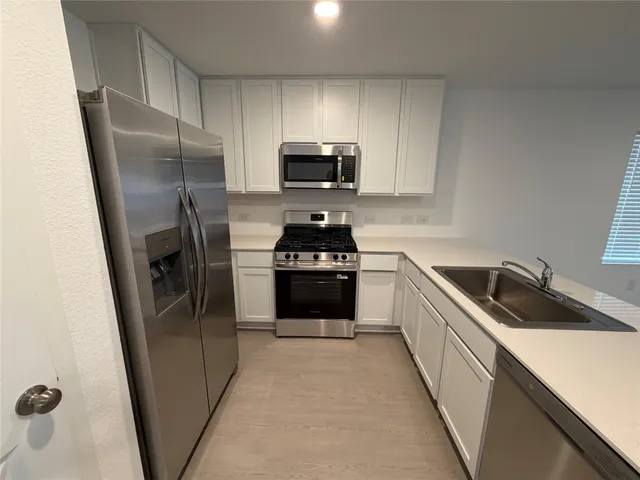 a kitchen with a refrigerator sink and microwave