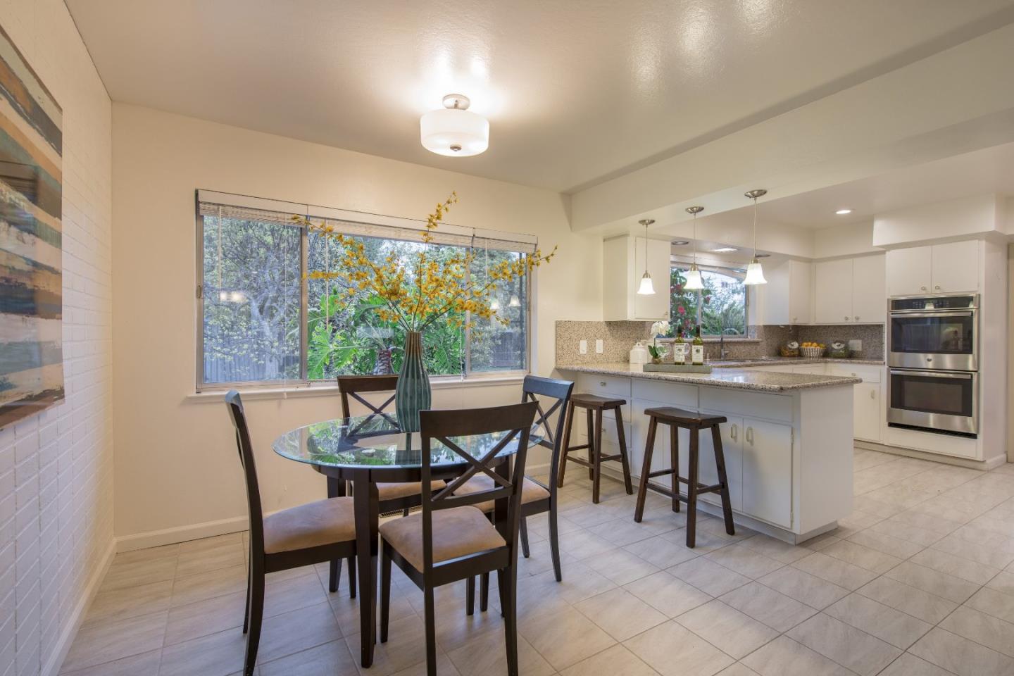 20249 Edinburgh Drive Saratoga, CA 95070 - Photo 10 of 32 a kitchen with a dining table chairs and refrigerator