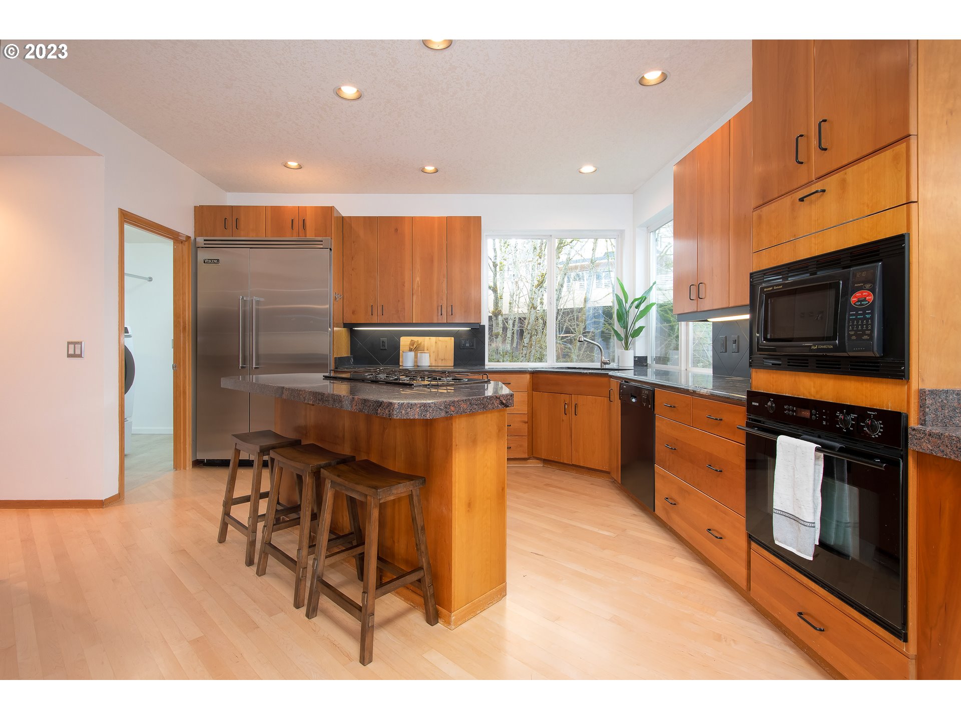 8208 Northwest Reed Drive Portland, OR 97229 - Photo 12 of 39 a kitchen with stainless steel appliances kitchen island granite countertop a stove a sink a microwave and a refrigerator