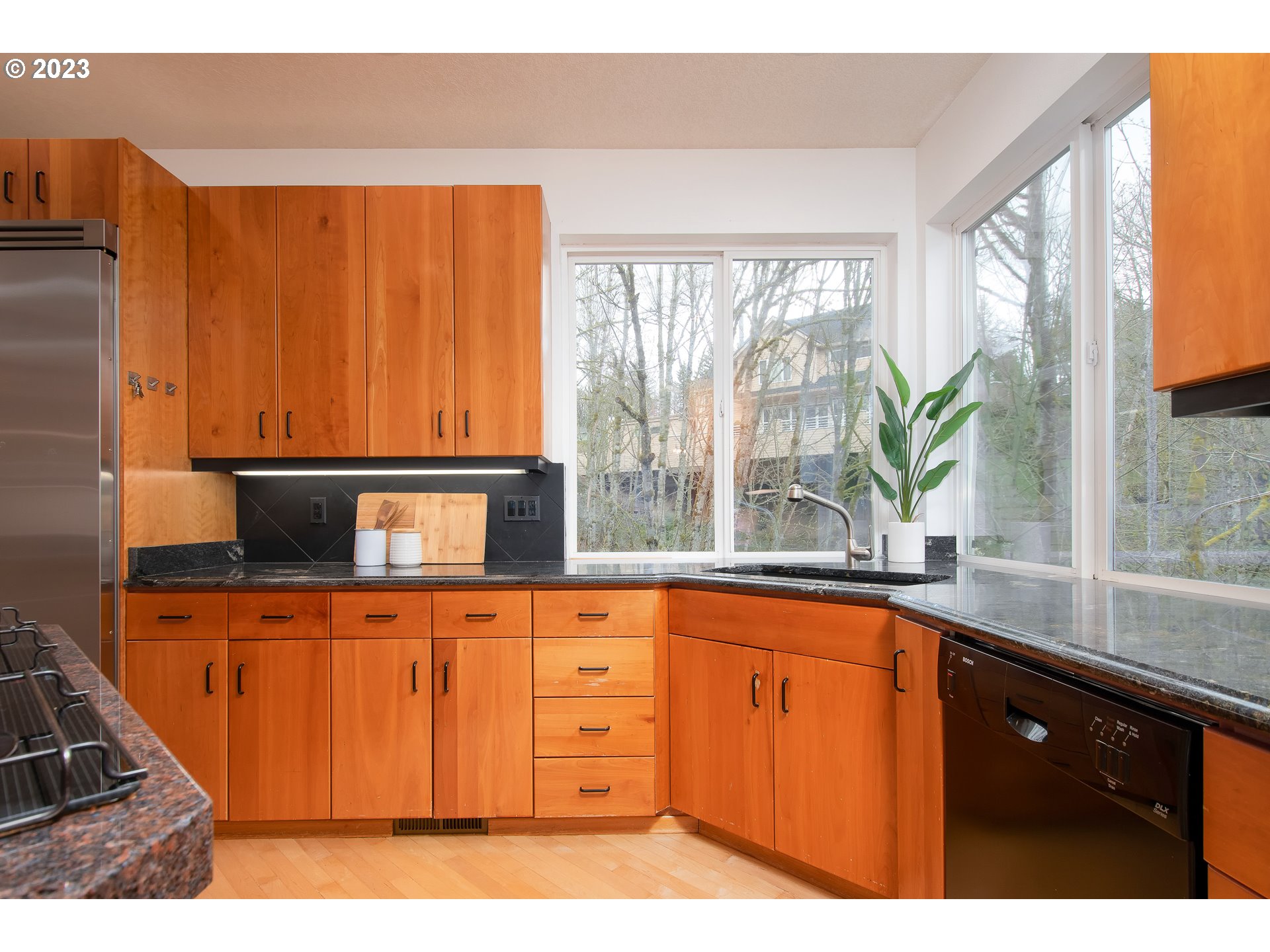 8208 Northwest Reed Drive Portland, OR 97229 - Photo 13 of 39 a kitchen with wooden cabinets a sink and a large window