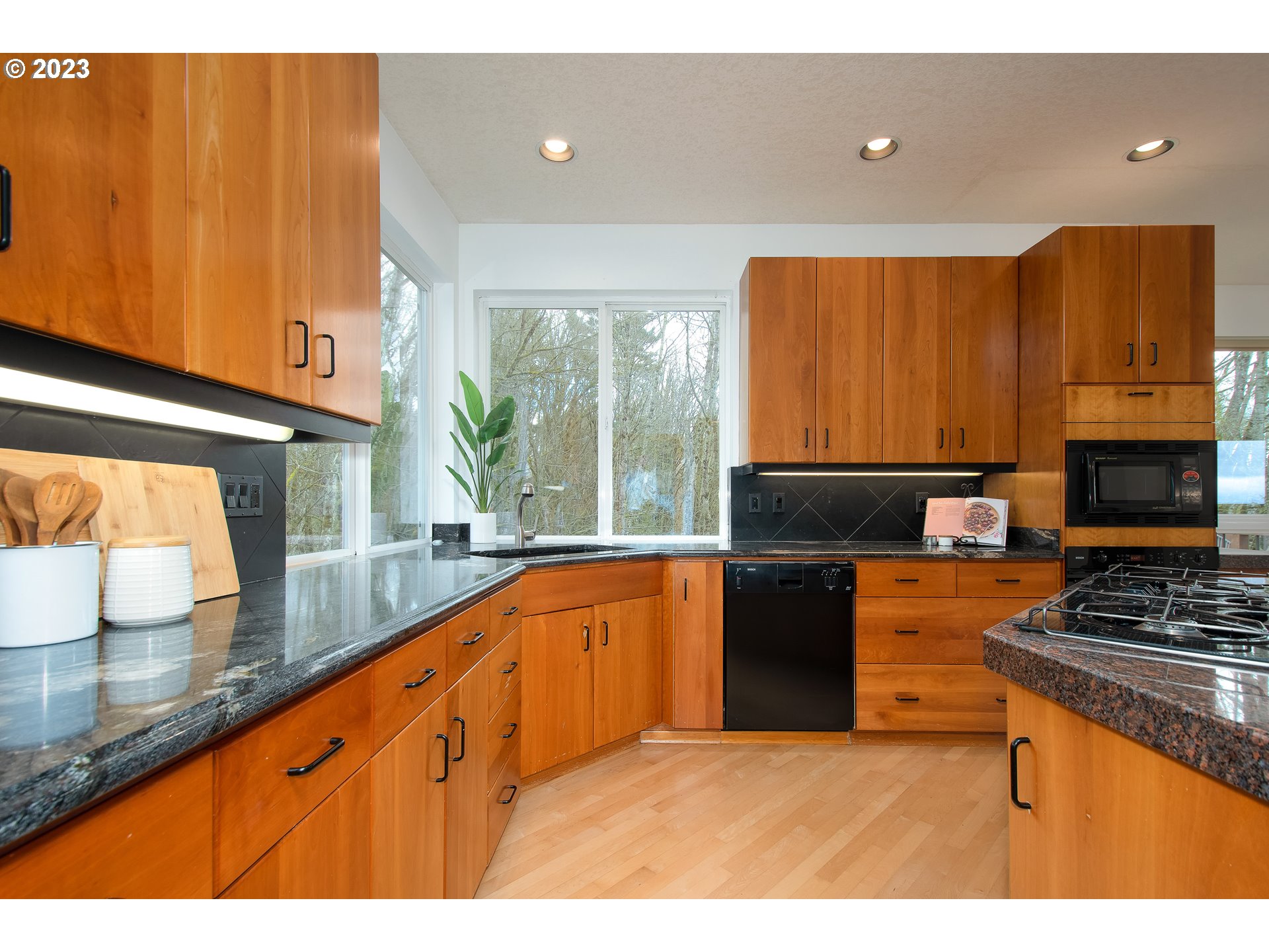 8208 Northwest Reed Drive Portland, OR 97229 - Photo 14 of 39 a kitchen with granite countertop a stove a sink and a microwave