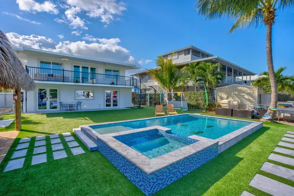 a view of an pool with lawn chairs under an umbrella