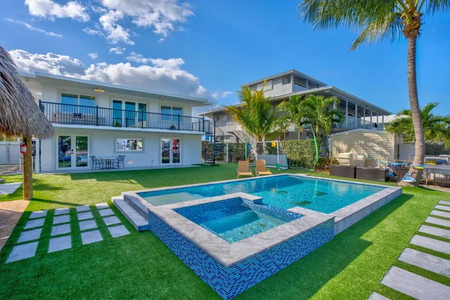 a view of an pool with lawn chairs under an umbrella