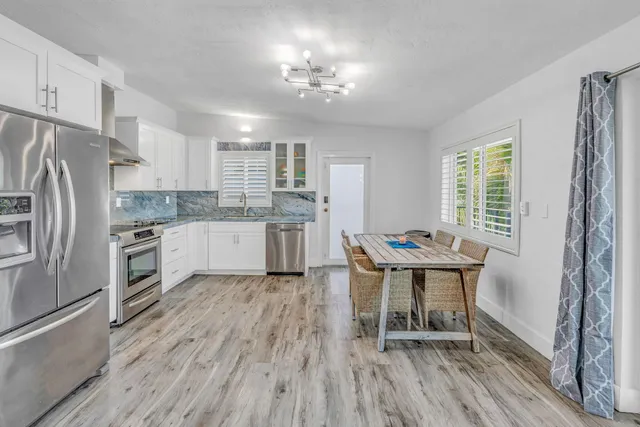 a kitchen with a table chairs refrigerator and window