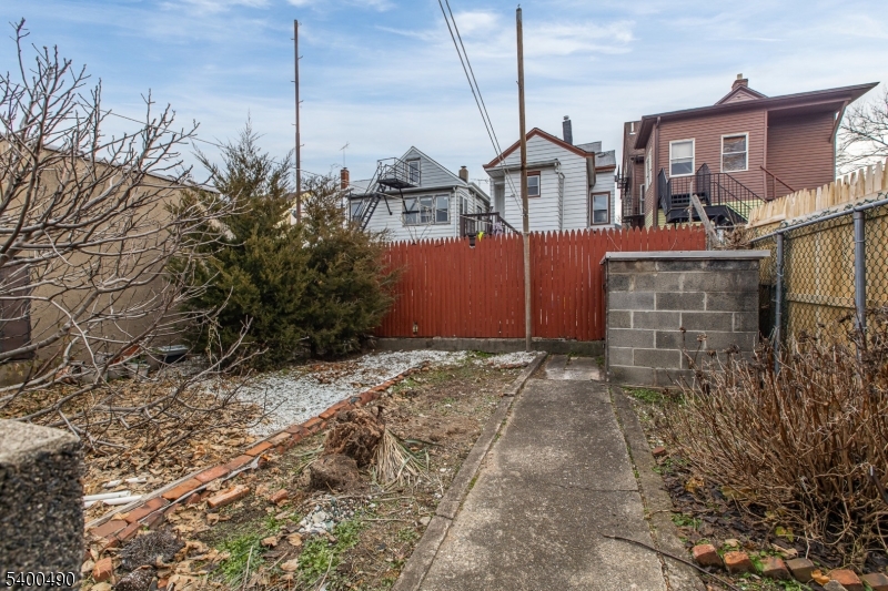 1029 East 19th Street Paterson, NJ 07501 - Photo 4 of 19 a front view of a house with a yard