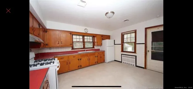 a kitchen with stainless steel appliances granite countertop a refrigerator and a stove