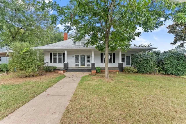 a front view of a house with yard patio and green space