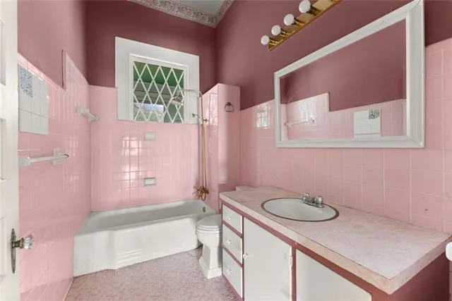 a bathroom with a sink a toilet a mirror and bathtub