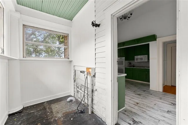a view of a hallway with wooden floor and a living room